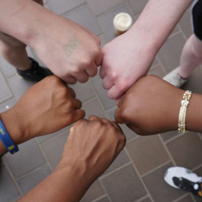 5 hands make fists and bumb each other